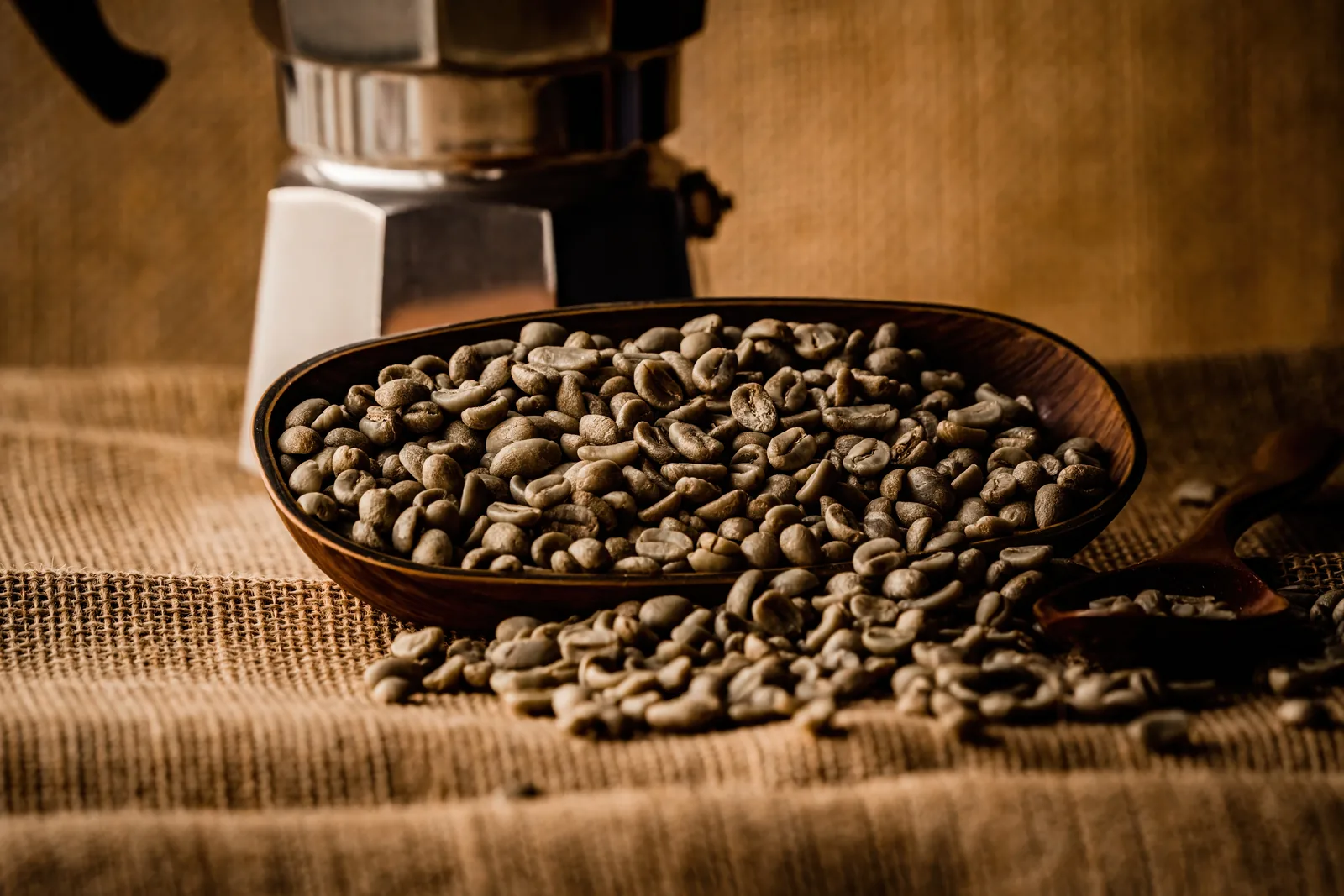 Green coffee beans in a wooden bowl